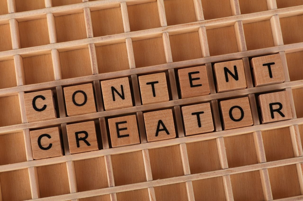 Wooden letter blocks arranged to spell 'Content Creator' symbolizing creativity and digital media.